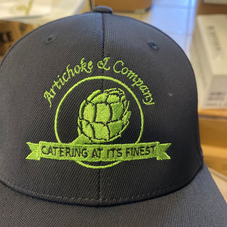 Black hat embroidered with the Artichoke & Company logo