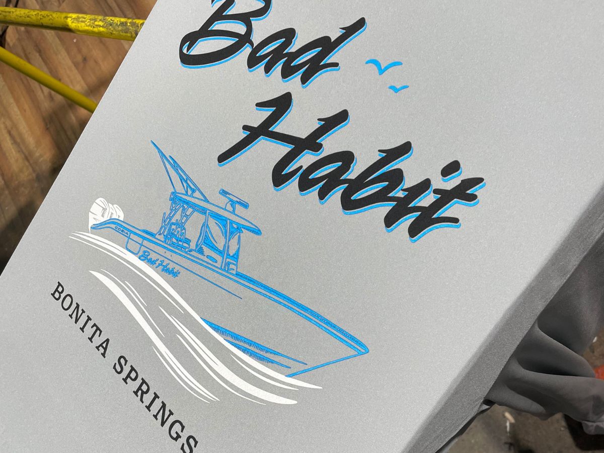 White tee with a blue Bad Habit boat graphic from Bonita Springs, FL