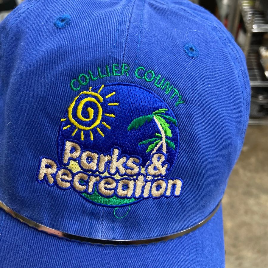 Blue cap embroidered with the Collier County Parks & Recreation logo