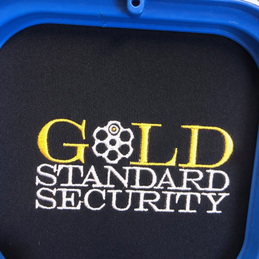 Gold Standard Security logo embroidered in gold and white