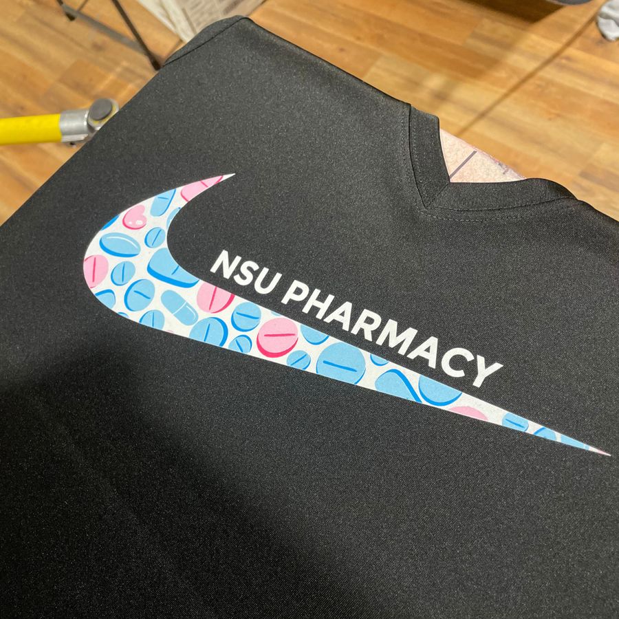 Black tee with a pink and blue NSU Pharmacy swoosh design