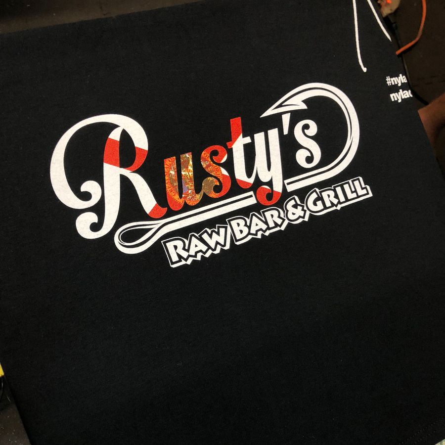 Black tee with the Rusty's Raw Bar & Grill logo in white and red