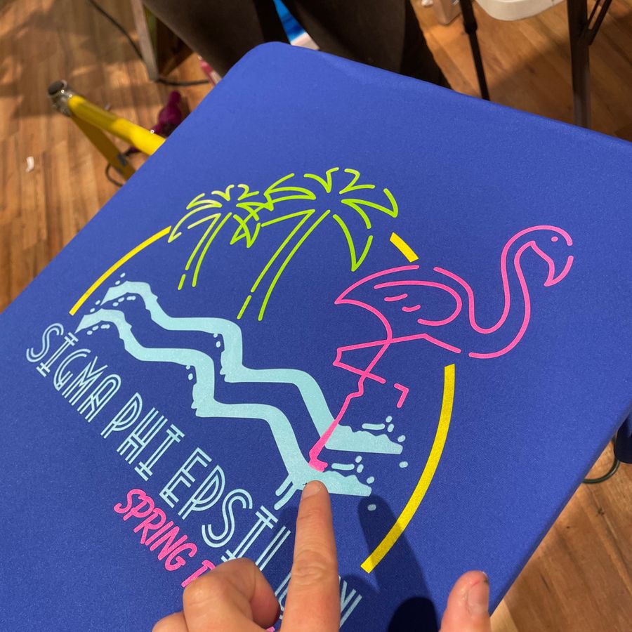 Blue tee with a neon flamingo Sigma Phi Epsilon Spring design