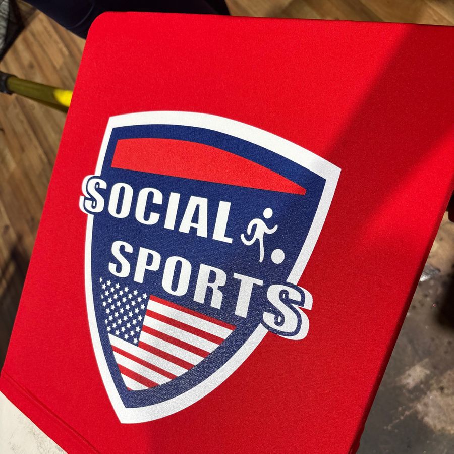 Red tee with a Social Sports shield logo