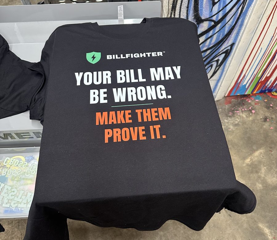 Black tee with a bold white and orange text print